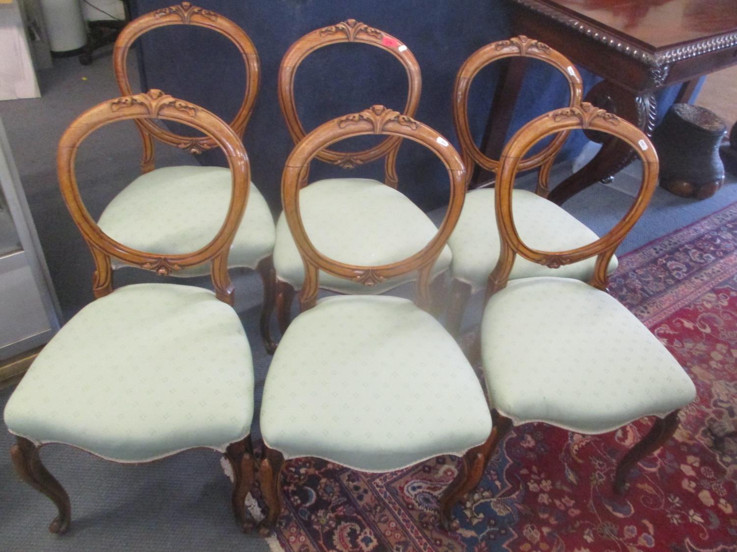 A set of six Victorian walnut balloon back dining chairs