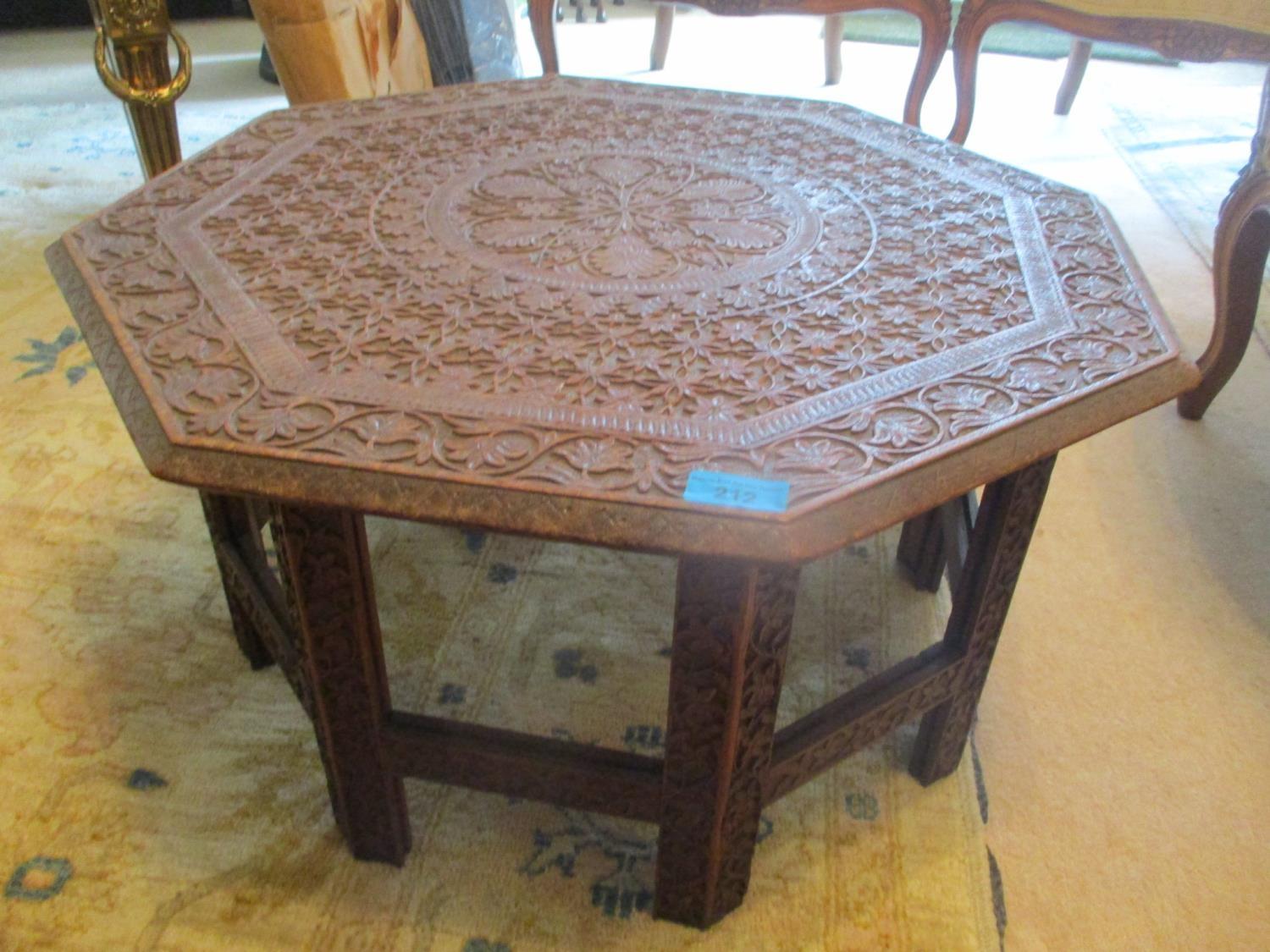 A carved teak hardwood occasional table, 12 3/4"h x 24"w Location: C