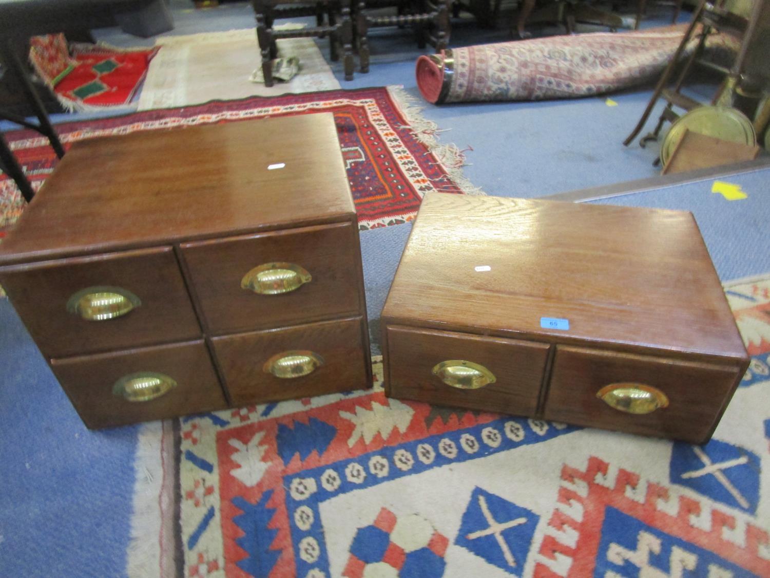 An early 20th century oak four drawer table cabinet with brass handles and a matching two drawer