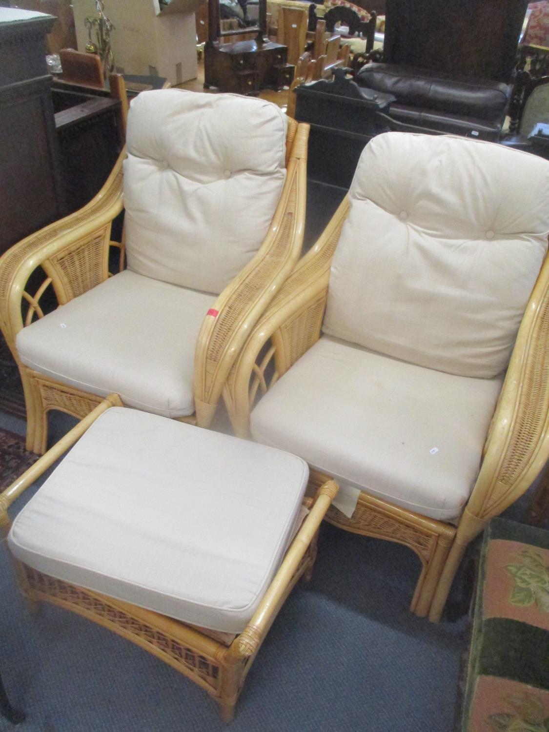 A pair of conservatory wicker armchairs and a foot stool together with a modern cream upholstered