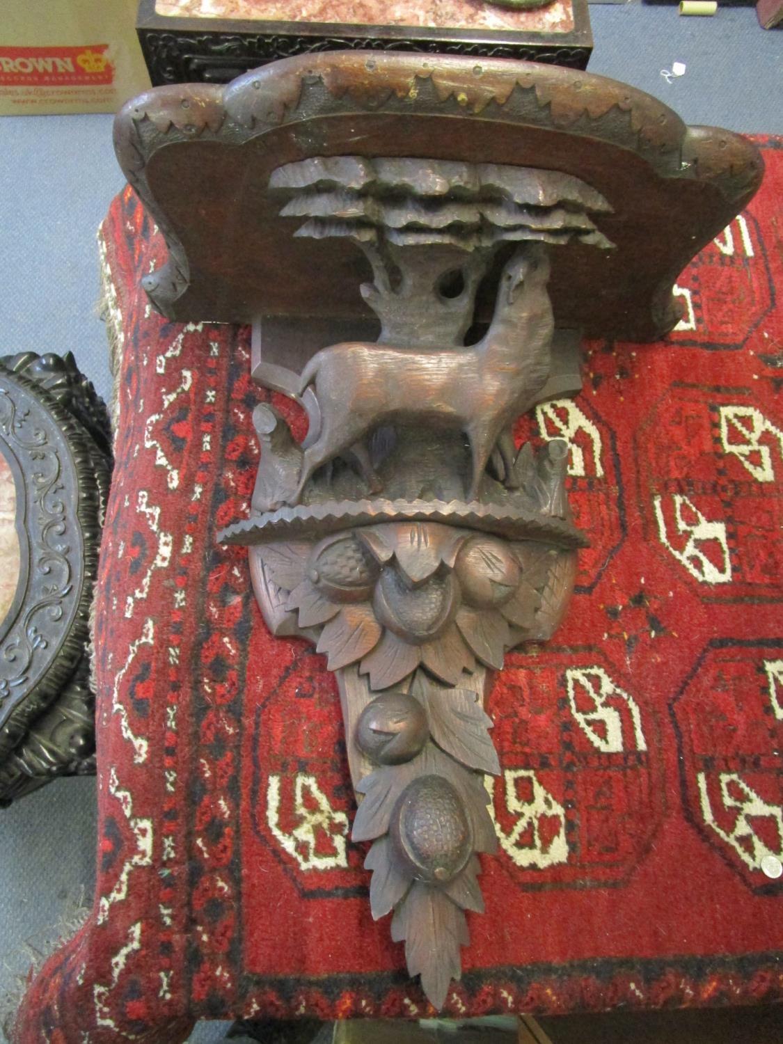 A late 19th century wooden Black Forest carved wall bracket, carved with a deer standing in front of