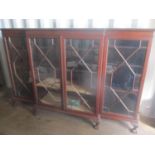 A 1920s mahogany large breakfront bookcase having four glazed doors and standing on ball and claw