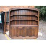 A large mid 20th century oak dresser with shelves over four linen fold panelled doors 214cm high x