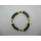 A Chinese jade coloured and yellow coloured metal four sectioned bracelet with character decorated