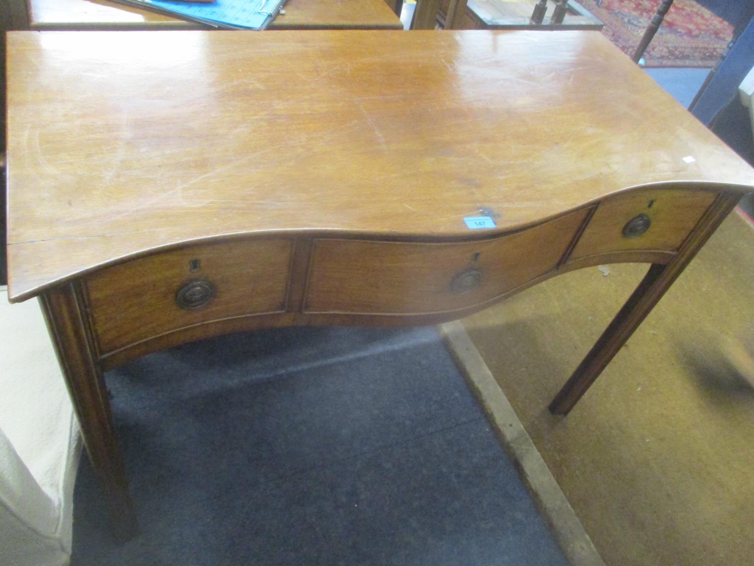 An early 19th century mahogany serpentine fronted three drawer sideboard, 77h x 110w