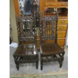 A pair of 18th century and later oak chairs with carved crests, barley twist supports and panelled