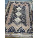 A hand knotted middle eastern blue ground rug with triple guard boarder 229cm x 172cm