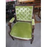 A late 19th century French walnut framed open armchair with carved ornament, upholstered in green