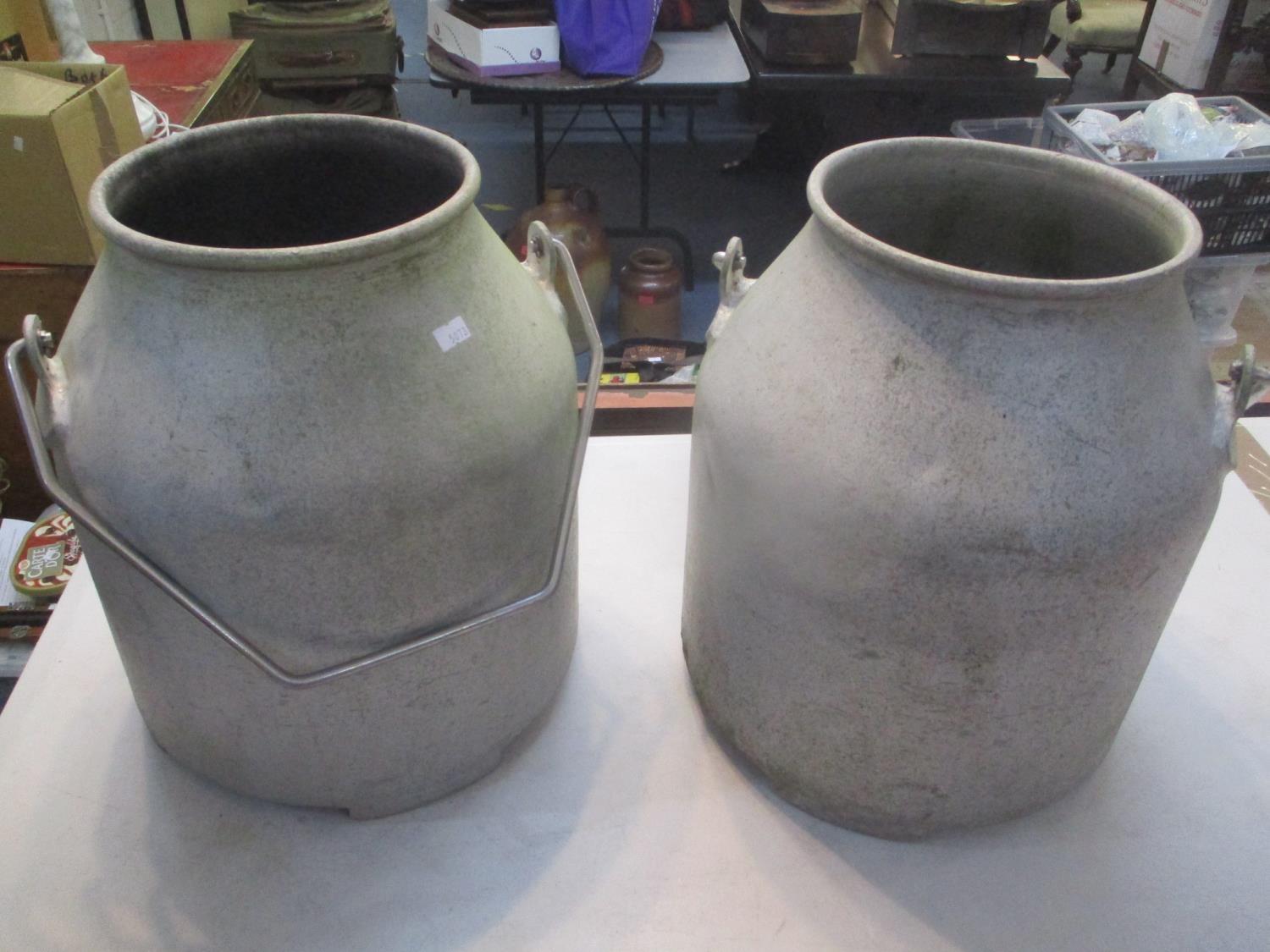 Two aluminium milk churns with swing handles Location: LWF