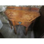 An early 20th century brown leather covered side table with a drawer and studwork on chamfered legs