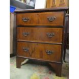 An early 20th century walnut three drawer chest on bracket feet