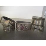 Five silver napkin rings to include one inset with an amethyst