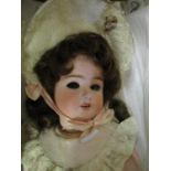 A Schoenau and Hoffmeister bisque headed doll, open mouth showing four teeth, composition jointed