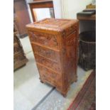 A modern Chinese carved wooden five drawer chest, decorated with landscapes, on cabriole feet