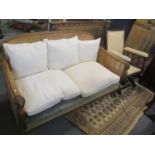 An early 20th century Bergere sofa, together with a late 19th century American rocking armchair