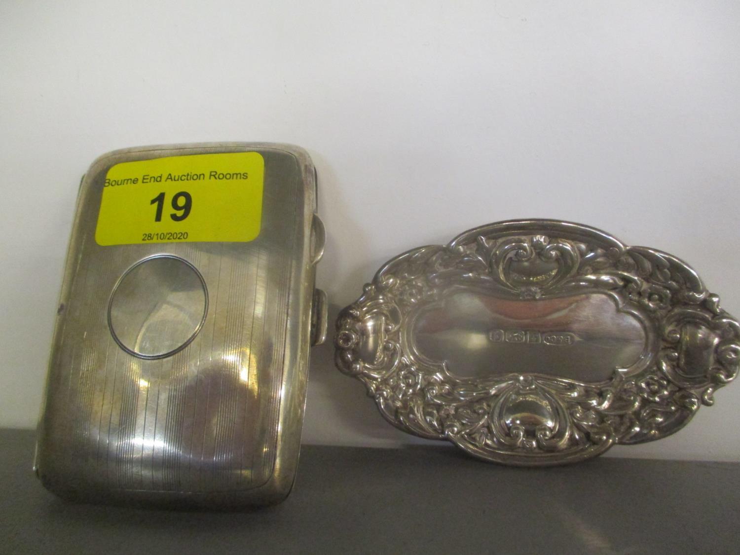 An early 20th century silver cigarette case, together with a silver embossed trinket dish, 84.9g