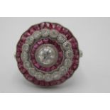 A platinum flower design ring set with bands of diamonds and calibre cut rubies Location: CAB