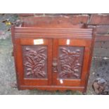 A late 19th/early 20th century oak carved, two door smokers cabinet, 45cm h x 42cm w