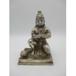 An Indian white metal model of a Hindu God Hanuman, the deity modelled in a half kneeling prayer