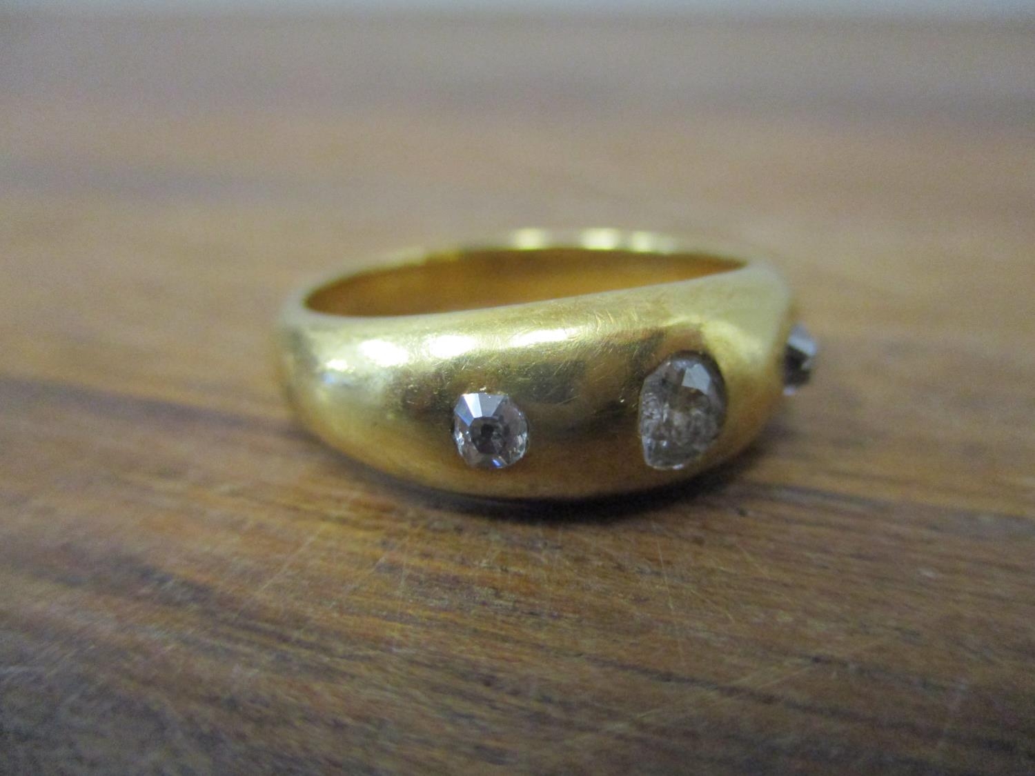 A gold coloured metal gypsy ring set with three diamonds, 9.5g