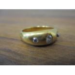 A gold coloured metal gypsy ring set with three diamonds, 9.5g