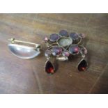 A gold coloured metal brooch set with garnet coloured cabochons A/F and a brooch set with a