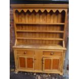 A Victorian pine dresser having a plate rack above two drawers and two cupboard doors 190cm h x