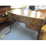 A walnut desk/dressing table having a central drawer flanked by two smaller drawers, 74 x 107 x 50