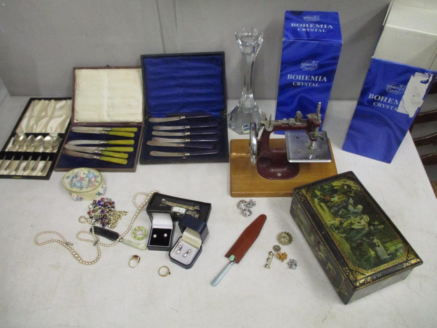 A mixed lot of costume jewellery, boxed silver plated cutlery and a child's sewing machine, along