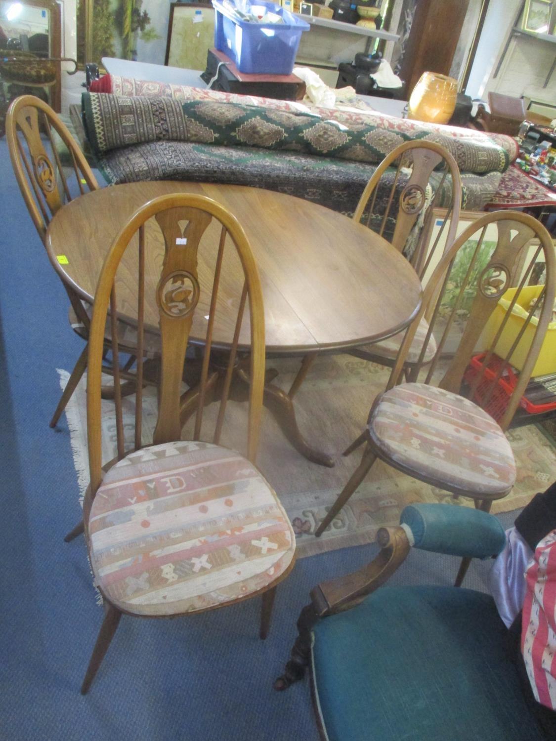 An Ercol Golden Dawn extending dining table, together with four Quaker Swan chairs