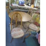 An Ercol Golden Dawn extending dining table, together with four Quaker Swan chairs