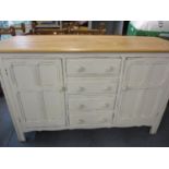 A mid 20th century sideboard painted white in the distressed manner, having a stripped light oak top