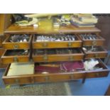 A reproduction side cabinet having brush slide and nine drawers containing a selection of silver