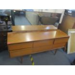 A mid 20th century teak retro dressing table having nine drawers and tapering legs