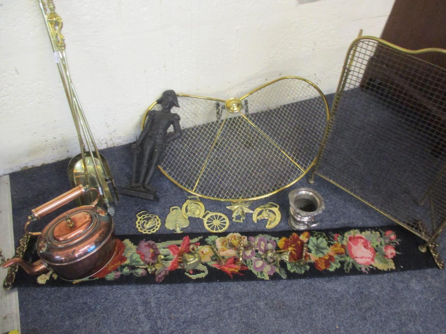 A quantity of brass fireside implements, guard and mixed metalware to include horse brasses.