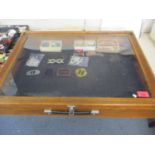 A mid 20th century oak table top/travelling display case and contents to include five buckles, glass