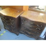 A pair of reproduction mahogany serpentine fronted chests of drawers having brushing slides above