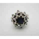 A sapphire and diamond snowflake cluster ring, in an unmarked white metal setting, with central