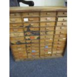 A vintage plywood collectors chest with drawers to the front and back and side handles