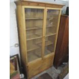 A 19th century and later pine cabinet having twin glazed doors above two drawers 220cm h x 121cm w