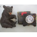 A Black Forest carving of a bear, teeth showing, together with a luminous dial bedside clock in a