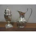 A Victorian silver cream jug with embossed ornament and a silver pepper pot with swag and reeded