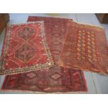 Three Middle Eastern red ground rugs having geometric designs and multiguard borders