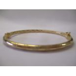 A 9ct gold bangle with engraved decoration 4.1g