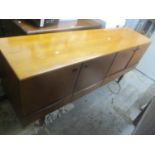 A mid 20th century retro teak sideboard having a fall flap flanked by two cupboard doors, 78.5h x