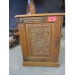 An Arts & Crafts carved oak smokers cabinet depicting peacocks A/F