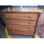 A Victorian mahogany chest of four long drawers having barley twist supports and bun shaped