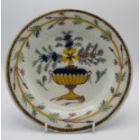 An 18th century continental Delft tin glazed plate, possibly Dutch, designed with polychrome flowers