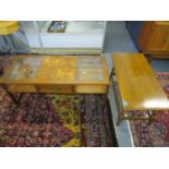 A modern coffee table with central drawer sliding out at both ends, flanked by inset glass tops