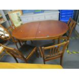 A retro style teak extending D-end dining table with rising extra leaf, and four dining chairs